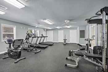 A spacious gym with a variety of equipment including treadmills, stationary bikes, and weight machines at Peachtree Place Apartments, Columbia, SC, 29210